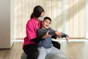 Fisioterapeuta tratando a un niño con discapacidad