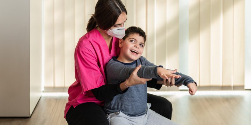 Fisioterapeuta tratando a un niño con discapacidad